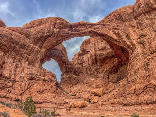 A view of the Double Arch structure from a short distance away.  For a sense of scale although hard to see, at the lowest point of the left gap, two people may be seen climbing around.